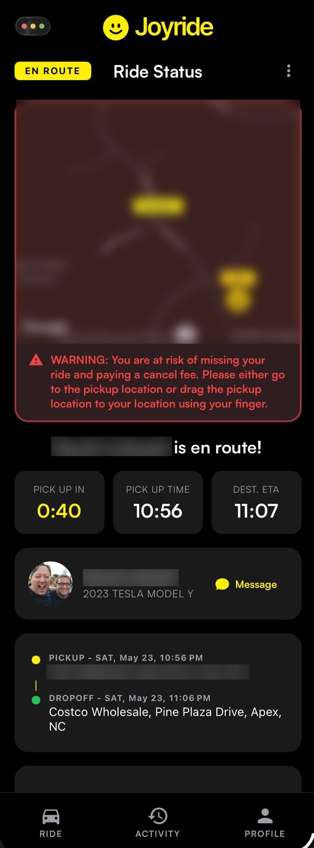 Joyride rider tracking screen showing the driver en route, with a warning that the rider is away from the pickup point.