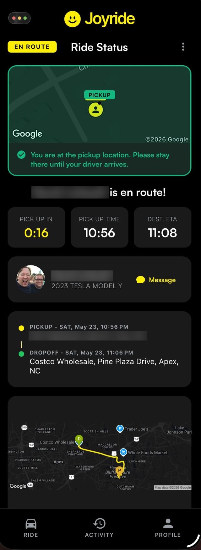 Joyride rider screen confirming the rider is at the pickup location while the driver is en route.